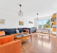 Living room of a three-room apartment with sofas, a table, and a wooden decor floor.