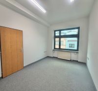 Office with one window, carpet, and door with wooden decor.