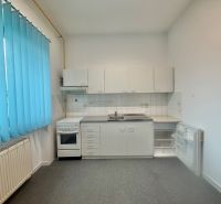 Kitchen area in Offices with white cabinets and blue blinds.