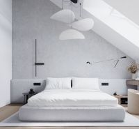 Elegant attic bedroom with a comfortable bed, writing desk, and wooden decor flooring.