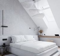A bedroom in a studio apartment with a bed, a skylight, and a wooden decor floor.