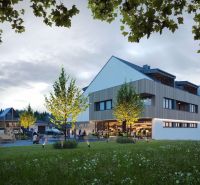 A building surrounded by trees and a playground in Mlynica, at sunset.