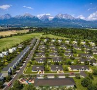 Aerial view of new residential buildings in Mlynica with a mountain backdrop.
