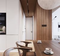 Dining area with wooden decor in a studio apartment, view of the kitchen and hallway.