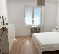 Bedroom in a 3-room apartment with a bed and a wooden decor floor.