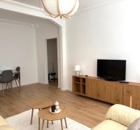 Living room in a 3-room apartment with a wooden decor floor and furniture.