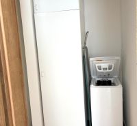 Bathroom with a washing machine in a 3-room apartment and a floor with a wood decor.