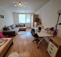 Living room in a 3-room apartment with a seating area and a desk, floor with wooden decor.