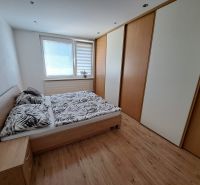 A bedroom in a 3-room apartment with a wooden decor floor and built-in wardrobes.