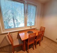 A dining table with four chairs in the kitchen of a three-room apartment.