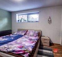 Bedroom in a family house with decorative flooring, bed, and wardrobe.