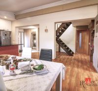 Interior of a family house with a dining room, fireplace, and floor with wooden decor.