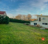 A family house in Suchá nad Parnou surrounded by a green lawn and a hedge.