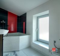 A bathroom in a family house with a corner bathtub and colorful tiles.