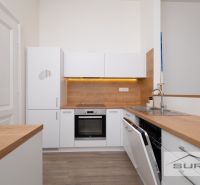 A kitchen in a 2-room apartment with a light decor and wooden elements.