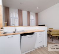 A kitchen with wooden decor and a dining table in a 2-room apartment.