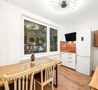 A kitchen in a 2-room apartment with a wooden decor floor and modern lighting.