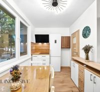 A kitchen in a 2-room apartment with a wooden decor floor and decorations on the table.