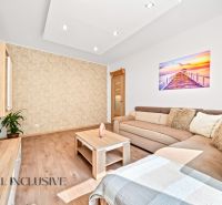 Living room with a sofa, a table, and a wooden decor floor in a 2-room apartment.