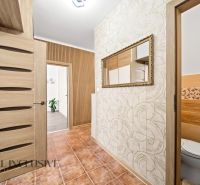 Interior of a 2-room apartment with tiles, a mirror, and doors with a wooden decor.