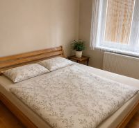 A bedroom with wooden furniture and a wooden decor floor in a family house.