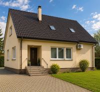 A family house in Šamorín with an asphalt roof, a front garden, and a paved access walkway.