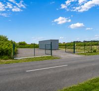 A plot for residential use in Modra on street 504 with fencing and a container.