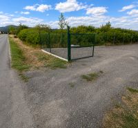 Lands - housing in Modra on street 504, fenced area, greenery, asphalt road.
