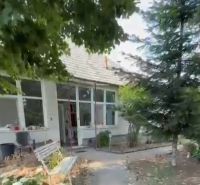 A family house in Imel with a bench, trees, and a garden path.