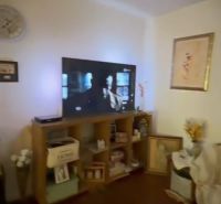 Living room in a family house with a television and a wooden decor floor.
