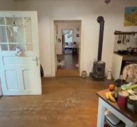 The interior of a family house with a wooden decor floor and a tiled stove.