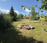 The garden of a family house in Čaradice surrounded by greenery and trees.