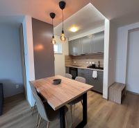 A kitchen in a family house with a wooden decor floor and hanging lamps.