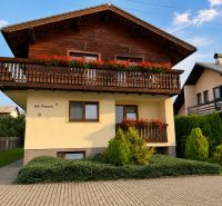 A family house on Hony Street in Liptovská Ondrášová with flowers on a wooden balcony.