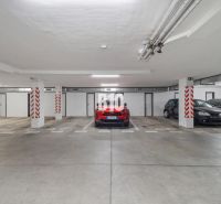 Underground garage with parked cars in a 4-room apartment in Nitra, concrete floor.