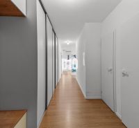 A hallway in a 4-room apartment with a wooden decor floor and storage space.