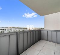 The balcony of a 4-room apartment in Nitra with a view of modern buildings.