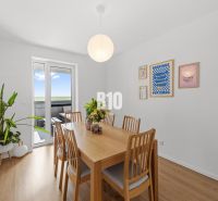 Dining room in a 4-room apartment with a wood-patterned floor and wall decorations.