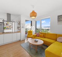 Living room of a 4-room apartment with a wooden decor floor and a yellow sofa.
