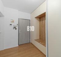 An entrance hall with light furniture and a wood-patterned floor in a 4-room apartment.