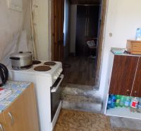 Cottage kitchen with a mix of furniture, electric stove, and wooden decor flooring.