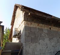 Cottage on the Pumpkin Field in Nové Zámky with a stone wall and an extension.