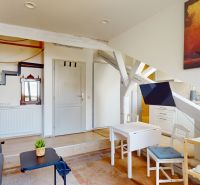 A compact 1-room apartment with a wooden decor floor and a glimpse of the kitchen.