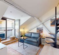 Attic studio apartment with a spiral staircase, sofa, and access to a terrace.