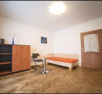 A room with a wooden floor decor in a 3-room apartment, with furniture and decoration.