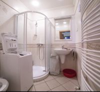The bathroom in the 3-room apartment includes a shower, a sink, and a washing machine.