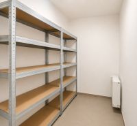 Storage space in a 4-room apartment with metal shelves and a radiator.