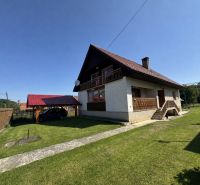 A family house in Liptovské Kľačany with a lawn and a carport.