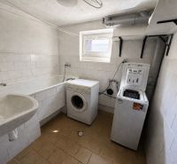 Bathroom in a family house with a bathtub and washing machines.