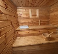 The family house includes a wooden sauna with a bucket and a towel on the bench.